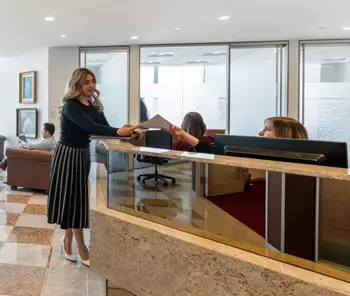 Premium coworking space at River Point, Chicago, where a client engages with the reception team for assistance.