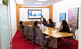 A team engages in a Servcorp meeting room presentation with modern tech, comfort, and executive style